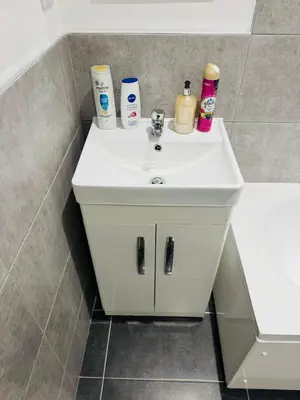 a bathroom sink with toiletries on top of it at Canvey Stay Entire Flat in Canvey Island