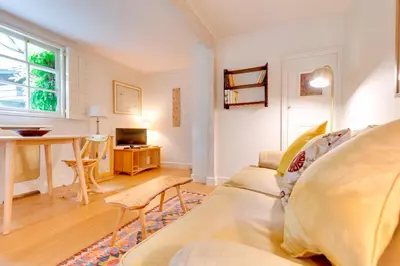 a living room with a couch and a table at Pass the Keys Charming Cottage in City Centre with Free parking in Cambridge