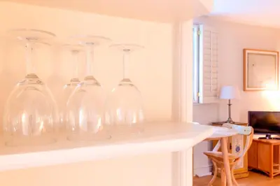 four glass wine glasses sitting on a shelf at Pass the Keys Charming Cottage in City Centre with Free parking in Cambridge