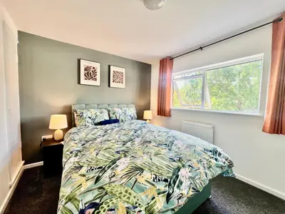 a bedroom with a bed and a window at 4 Bedroom House in the Heart of Basildon 2 mins to Town Center I Weekly or Monthly Stay Offer I Free Parking I Sleeps 7 in Basildon