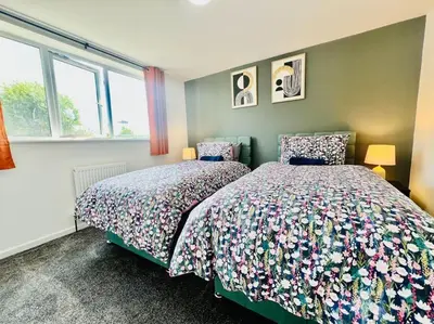 a bedroom with two beds and two windows at 4 Bedroom House in the Heart of Basildon 2 mins to Town Center I Weekly or Monthly Stay Offer I Free Parking I Sleeps 7 in Basildon