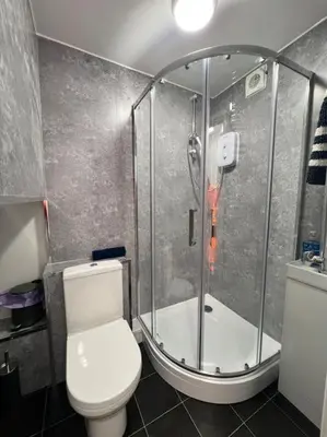 a bathroom with a shower and a toilet at 4 Bedroom House in the Heart of Basildon 2 mins to Town Center I Weekly or Monthly Stay Offer I Free Parking I Sleeps 7 in Basildon