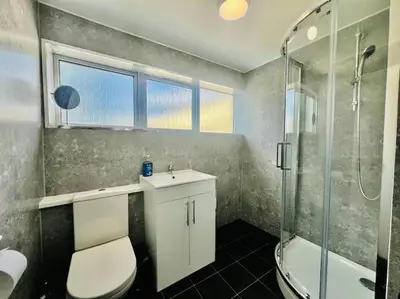 a bathroom with a toilet and a sink and a shower at 4 Bedroom House in the Heart of Basildon 2 mins to Town Center I Weekly or Monthly Stay Offer I Free Parking I Sleeps 7 in Basildon
