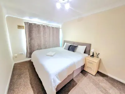 a bedroom with a large white bed and a window at Cosy Luxurious Large 3 bedroom house, free parking, free WiFi in Havering atte Bower