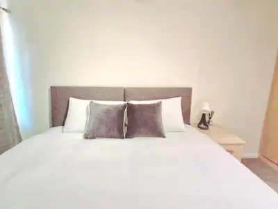 a bedroom with a white bed with two pillows at Cosy Luxurious Large 3 bedroom house, free parking, free WiFi in Havering atte Bower