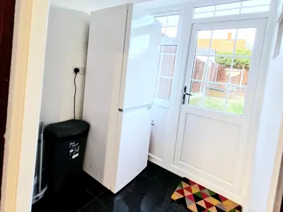 a room with a white door and a trash can at Cosy Luxurious Large 3 bedroom house, free parking, free WiFi in Havering atte Bower