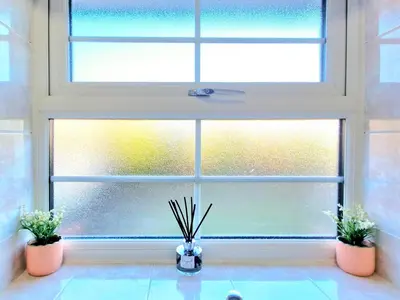 a window with two potted plants in front of it at Cosy Luxurious Large 3 bedroom house, free parking, free WiFi in Havering atte Bower