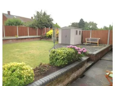 a backyard with a garden with a bench and flowers at Cosy Luxurious Large 3 bedroom house, free parking, free WiFi in Havering atte Bower