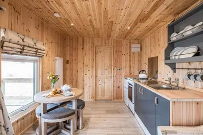 a kitchen with wooden walls and a wooden ceiling at River Retreat, Aldeburgh in Aldeburgh