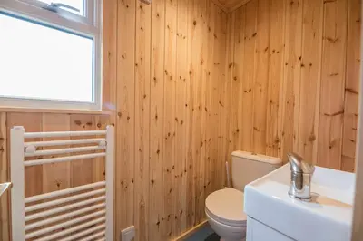 a bathroom with a toilet and a sink and a window at River Retreat, Aldeburgh in Aldeburgh