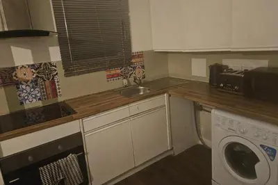 a kitchen with a sink and a washing machine at 1 Bed House Sleeps 2 -Free Parking -Tv in Romford