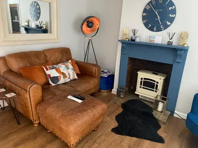 a living room with a couch and a fireplace at Sun lane cottage in Woodbridge