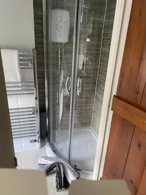 a shower with a glass door in a bathroom at Sun lane cottage in Woodbridge