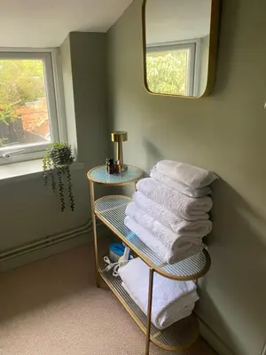 a pile of towels on a rack in a bathroom at Sun lane cottage in Woodbridge