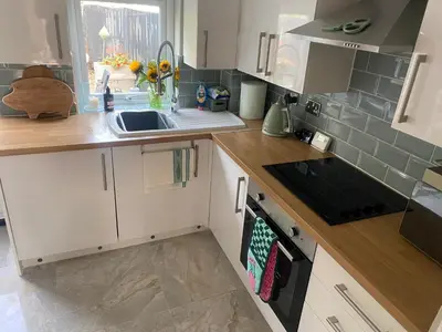a kitchen with white cabinets and a sink at Sun lane cottage in Woodbridge