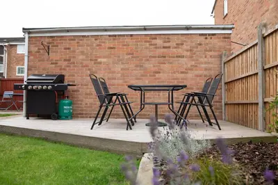 a patio with a table and chairs and a grill at Lovely 3 Bedroom House in Chelmsford in Chelmsford