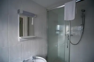 a bathroom with a shower and a sink and a mirror at Brewers Inn in Cambridge