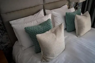 a bed with white pillows and green and white pillows at Brewers Inn in Cambridge