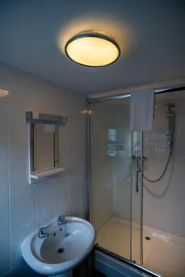 a bathroom with a shower and a sink and a glass shower stall at Brewers Inn in Cambridge