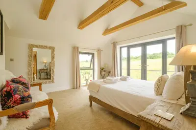 a bedroom with a bed and a large window at Sandown in Snape