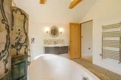 a white bath tub in a bathroom with a sink at Sandown in Snape