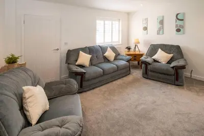 a living room with a couch and two chairs at 1 Buxlow Cottages in Aldringham