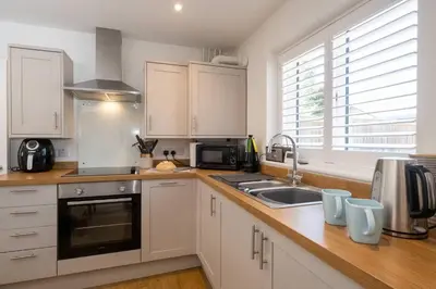 a kitchen with white cabinets and a sink at 1 Buxlow Cottages in Aldringham