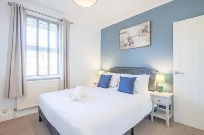 a bedroom with a large white bed and a window at Stylish 2-Bedroom House in the Heart of Cambridge in Cambridge