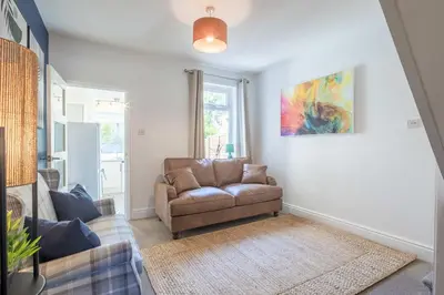a living room with a chair and a painting on the wall at Stylish 2-Bedroom House in the Heart of Cambridge in Cambridge