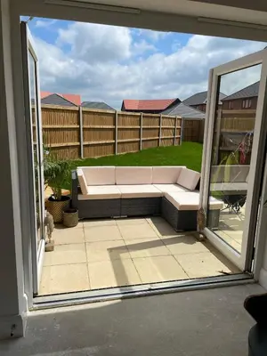 a view of a couch through an open window at Cosy room in Great Bromley