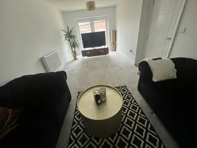 a living room with two couches and a table at Cosy room in Great Bromley