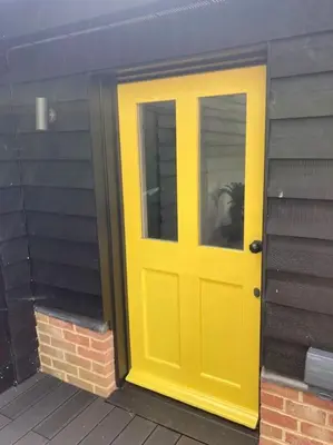 a yellow door on the side of a building at Wood Lodge in Bungay
