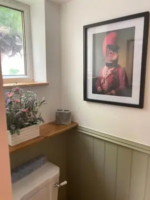 a bathroom with a picture of a man on the wall at Wood Lodge in Bungay