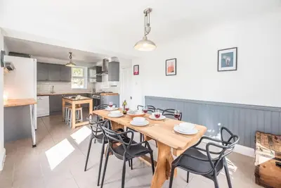a kitchen and dining room with a wooden table and chairs at The Red House, Leiston in Woodbridge