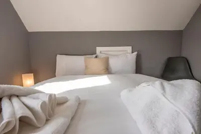 a bedroom with a large white bed with towels on it at The Red House, Leiston in Woodbridge