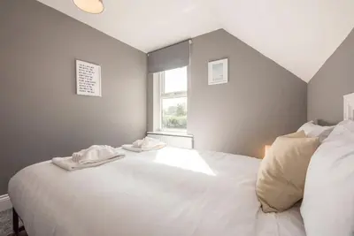 a bedroom with a large white bed with a window at The Red House, Leiston in Woodbridge