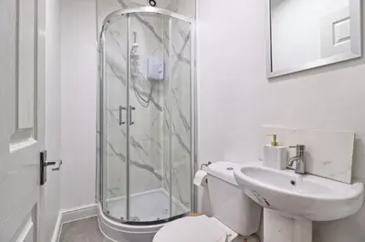 a bathroom with a shower and a toilet and a sink at Ivy on Sea Villa in Southend-on-Sea