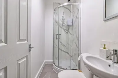 a bathroom with a shower and a toilet and a sink at Ivy on Sea Villa in Southend-on-Sea