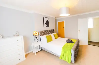 a bedroom with a white bed and a white dresser at Contractor's Haven 4BED 2BATH House in Ipswich with FREE Parking in Ipswich