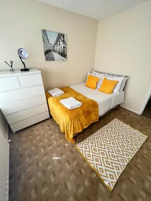 a bedroom with a bed with a dresser and a rug at Contractor's Haven 4BED 2BATH House in Ipswich with FREE Parking in Ipswich