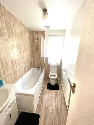 a bathroom with a tub and a toilet and a sink at Contractor's Haven 4BED 2BATH House in Ipswich with FREE Parking in Ipswich