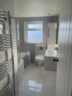 a bathroom with a toilet and a sink and a window at Modern Luxe Maisonette Near Station With Free Parking in Billericay