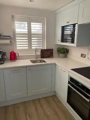 a kitchen with white cabinets and a sink at Modern Luxe Maisonette Near Station With Free Parking in Billericay