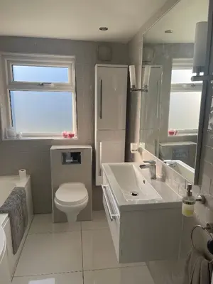 a white bathroom with a toilet and a sink at Modern Luxe Maisonette Near Station With Free Parking in Billericay