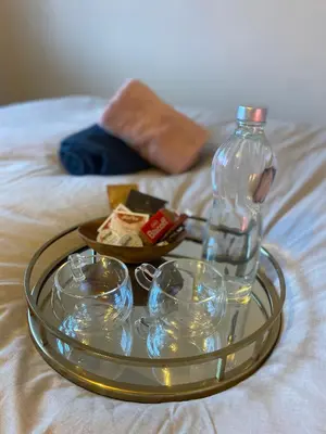 a tray with bowls and a bottle on a bed at relaxed and peaceful #2 in St Ives