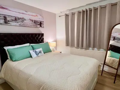 a bedroom with a bed with green and white at Bibis Home - Hertford in Hertford