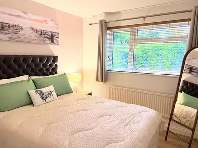 a bedroom with a large bed and a window at Bibis Home - Hertford in Hertford