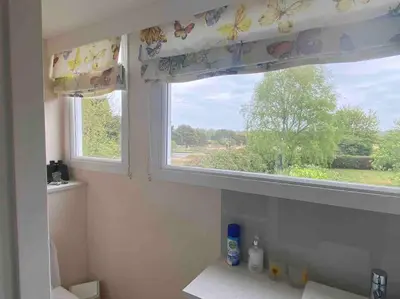 a bathroom with a window with a view of a field at Tresco - Aldeburgh's hidden gem in Aldeburgh