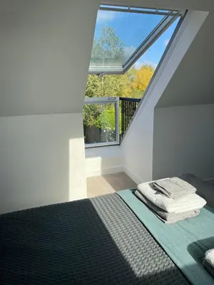 a bedroom with a bed and a large window at The Snug at Fourleys in Woodhurst
