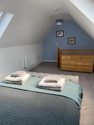 a bedroom with a bed with towels on it at The Snug at Fourleys in Woodhurst